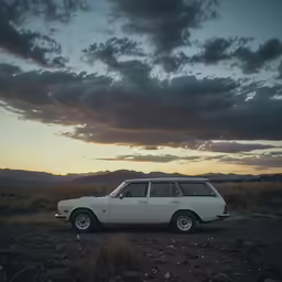 a white and black car is in a rocky field with the sunset