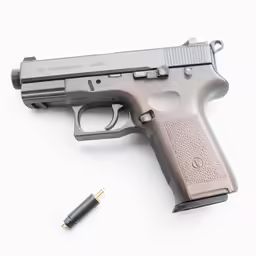 a gun, a bullet and some pen on a white surface