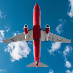an airplane flies through a blue cloudy sky