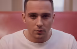 a man stares at the camera with a serious look