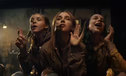 the three women are all clapping in the middle of the picture