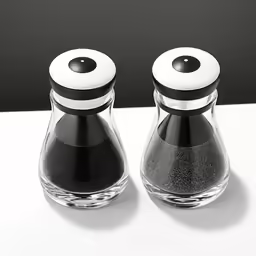 two salt and pepper shakers next to each other on a counter