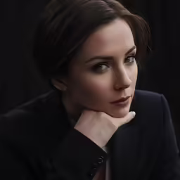 woman wearing dark clothes looking over her shoulder