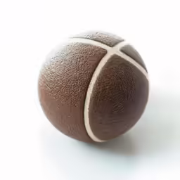 an old, leather tennis ball sits on the ground