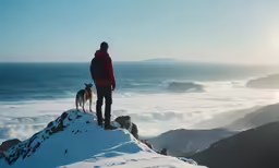 a person standing on top of a snow covered hill next to a dog