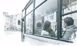 two people are seen looking out the windows of a bus
