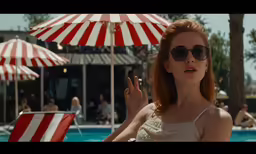a woman in sunglasses is standing in front of the pool