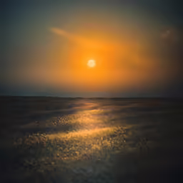 the sun is setting over a big ocean
