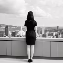 a woman standing on top of a building near a wall