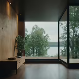 view of a lake through large windows from a living room