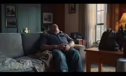 a man sitting on top of a couch in a living room
