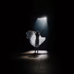 a person standing in front of a light in the dark