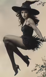 a woman in a dress is posing with a witches hat and a wand