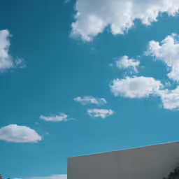 the view of white clouds with the building and trees