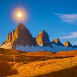 a beautiful sunset on a mountain range with the sun shining in the distance