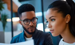 a man and woman looking over paperwork together