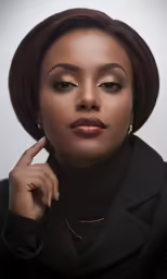 a woman posing for a portrait while wearing gold eye makeup