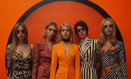 four models standing side by side in front of a wall