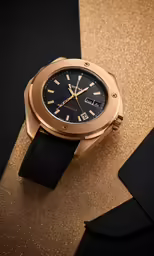a watch is on a shiny surface with black and gold
