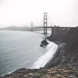 an ocean scene with a bridge and a large body of water