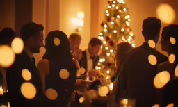 a group of people standing around a christmas tree