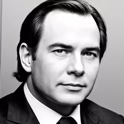 black and white photograph of man in suit looking to camera
