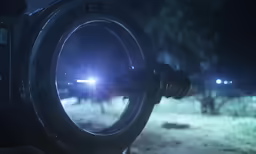 a camera lens with snow and lights in the background