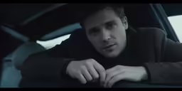 a man with his arms resting on the door of a car