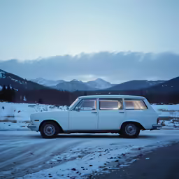 a old station wagon sitting in the snow at night