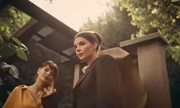 two women in jackets are looking at something