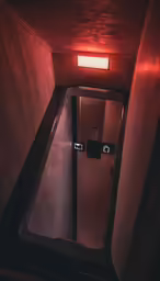 the entrance to a very small bathroom with its lighting on