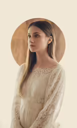 a woman wearing white, a cream dress with sheer shoulders and long sleeves