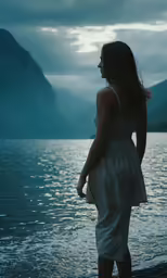 a woman in a white dress looking at the mountains
