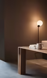 a lamp a coffee cup a table and two books