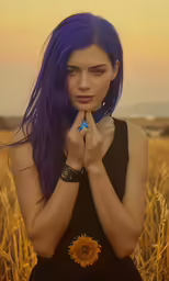 an attractive young woman in black dress holding her hands to her chest