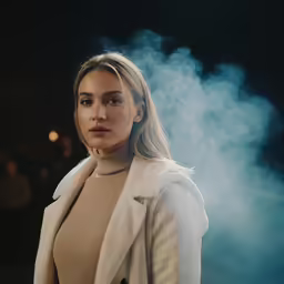 a woman standing in front of smoke pouring out of her mouth