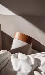 the top of a bed with sheets and a paper bag on it