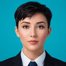 the woman with blue eyes and tie is looking at the camera