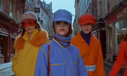 three girls walking down the street in hats and sunglasses