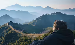 a man is looking at the beautiful scenery on top of a mountain