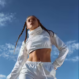 a girl with braids is posing on a ladder