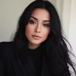 an asian woman wearing black with her long hair styled back and side view
