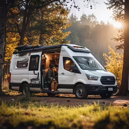 two people sitting in the open van on a dirt path
