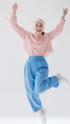 a woman dressed in pink, dancing on a white surface