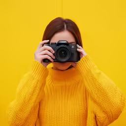 a girl holding a camera up against her face