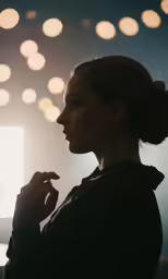 a girl standing in front of some lights