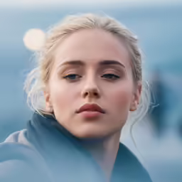 a woman with blonde hair looking at the camera