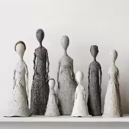 an arrangement of clay figures sitting on a shelf