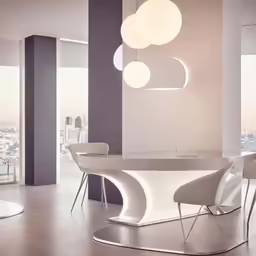 a very modern dining room with white furniture and hanging lights