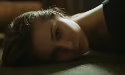 a close up of a woman lying on the floor